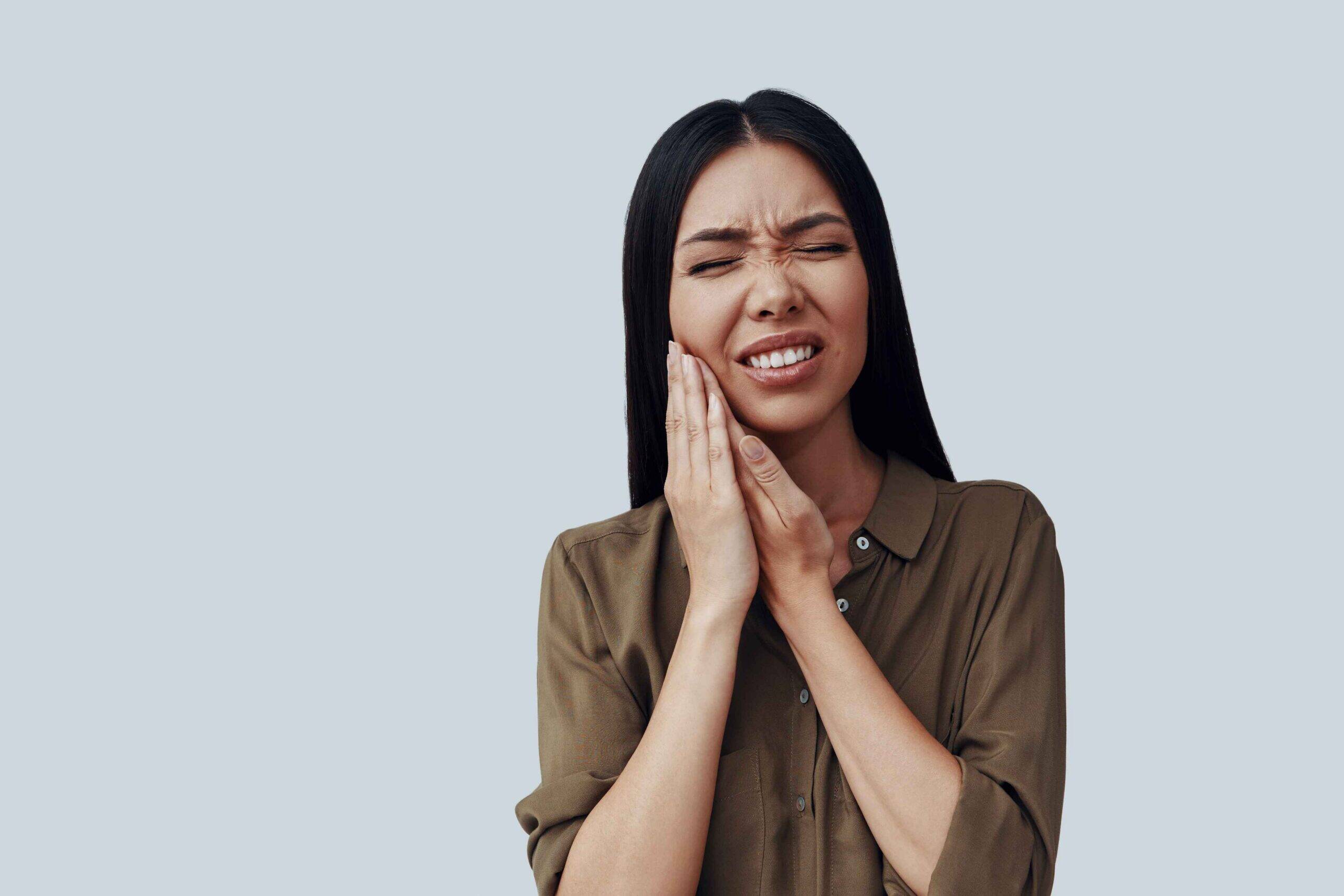 pain-swelling-broken-tooth-urgent-dental-care-pittsfield-township-mi Woman holding her jaw with a painful toothache.